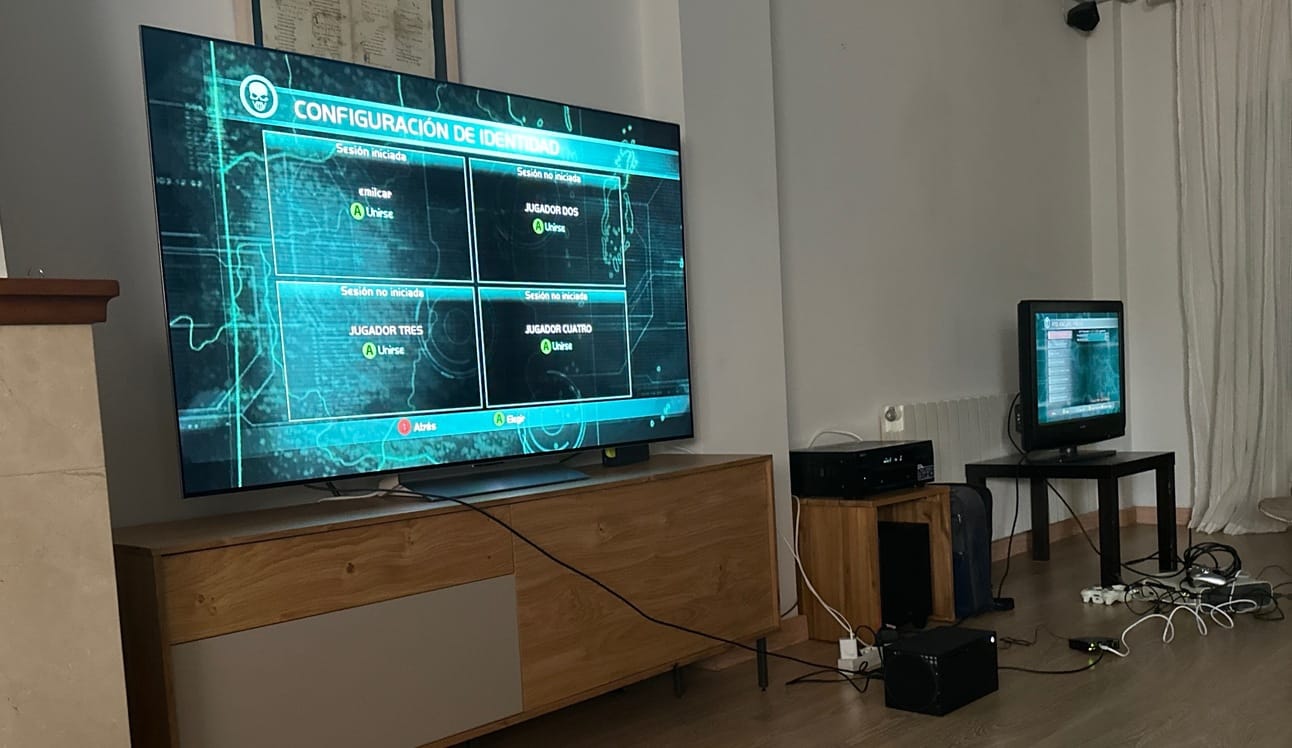 Foto de las dos consolas tiradas en el suelo y rodeadas de cables, conectadas a todos teles.